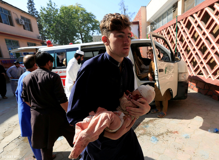 Sérült gyereket visz kórházba egy férfi bombatámadás után Jalalabadban 2020. október 3-án