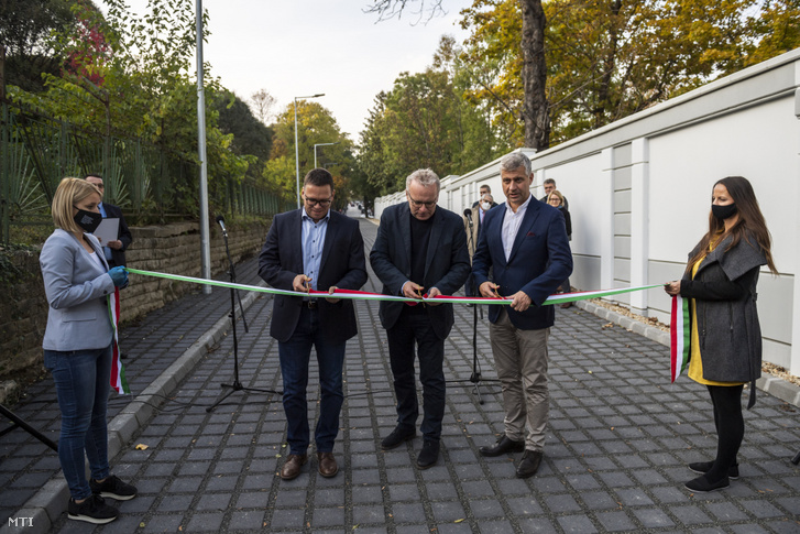 Fürjes Balázs Budapest és a fővárosi agglomeráció fejlesztéséért felelős államtitkár Pokorni Zoltán, a XII. kerület polgármestere és Szatmáry Kristóf, a Budapesti Útépítési Program koordinálásáért felelős miniszteri biztos (b-j) a nemzeti színű szalag átvágásával átadja a Budapesti Útépítési Program támogatásával 200. útszakaszként elkészült Gyógyfű utcát 2020. október 22-én