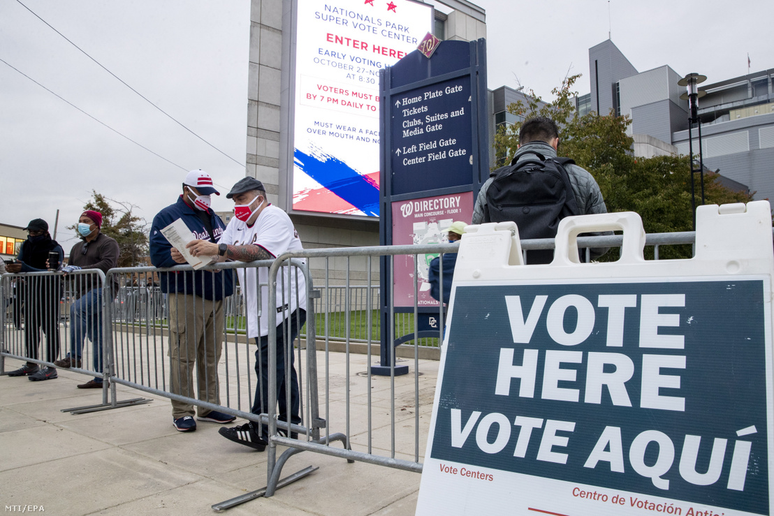 Szájmaszkot viselő emberek várakoznak egymástól biztonságos távolságra, hogy leadják szavazatukat a korai voksolásra kijelölt szavazóhelyiségek egyikében Washingtonban 2020. október 27-én