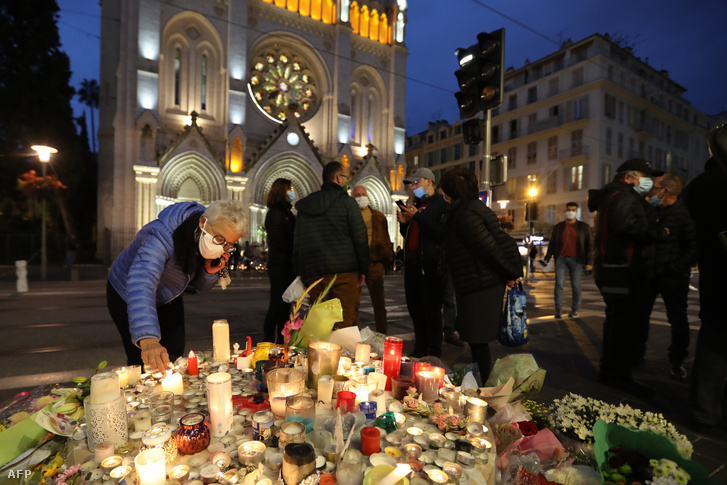 Nő gyújt gyertyát a Notre-Dame-székesegyháznál a késes támadás áldozataira megemlékezve 2020. október 31-én