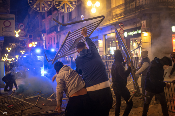A koronavírus terjedése miatt újra bevezetett korlátozó intézkedések miatt tüntetők fémkordonokat hajítanak a rendőrök felé Barcelona központjában 2020. október 30-án éjjel. Katalóniában a hétvégére lakhelyelhagyási tilalmat rendeltek el, és az éjszakai kijárási tilalom is érvényben van. A tavaszi karantén után ismét bezártak a vendéglátóhelyek, a mozik, a színházak és az edzőtermek.