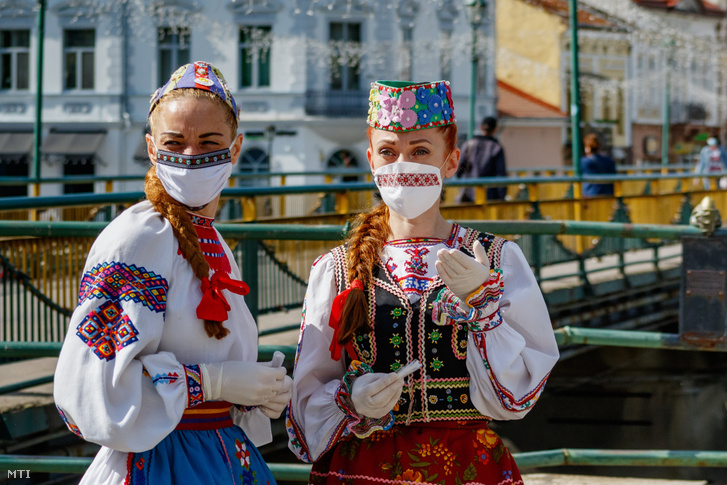 A Kárpátaljai Érdemes Népi Együttes védőmaszkot viselő, népviseletbe öltözött tagjai Ungvár belvárosában 2020. május 21-én. Az együttes tagjai hímzett védőmaszkokat osztottak a járókelőknek az ukrán hímzett ing, a Visivanka világnapja alkalmából.