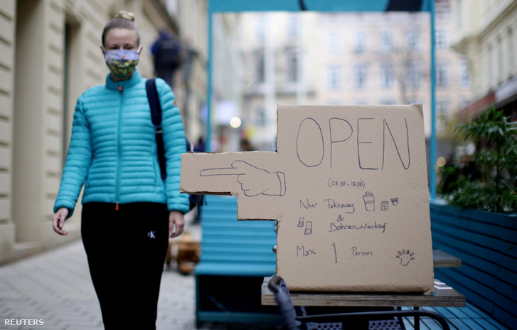 Kávézó táblája mellett sétál el Bécsben, amin az olvasható, hogy csak elvitelre lehet vásárolni a lezárás ideje alatt, 2020. november 4-én