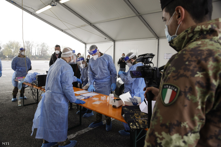 Védőfelszerelést viselő egészségügyi katonák a kórházak tehermentesítésére felállított, koronavírus gyorsvizsgálatot végző állomáson dolgoznak Lombardia székhelyén, Milánóban 2020. november 13-án
