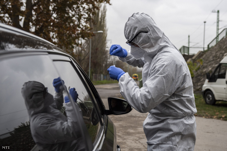Koronavírusteszthez vesz mintát az Országos Mentőszolgálat (OMSZ) munkatársa az OMSZ Pók utcai szűrőbuszánál Óbudán 2020. november 13-án. Szűrőbuszok is segítik a koronavírus-gyanús esetek kiszűrését.
