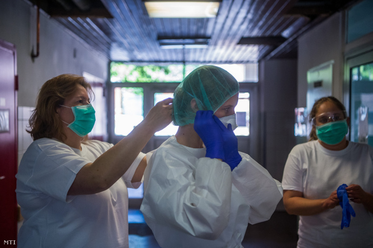 Ápoló segít védőfelszerelésbe beöltözni egy orvosnak a koronavírussal fertőzött betegek fogadására kialakított Covid Ortopéd-Traumatológiai Osztályon a fővárosi Szent János Kórházban 2020. május 14-én