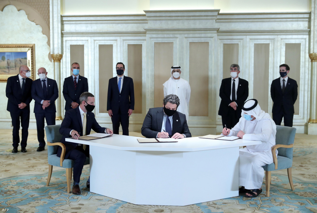 Emirátusok és izraeli küldöttek szerződést írnak alá az első Abraham Accords üzleti találkozón Abu-Dzabiban 2020. október 19-én, az amerikai Steven Mnuchin pénzügyminiszter (hátul középen) jelenlétében