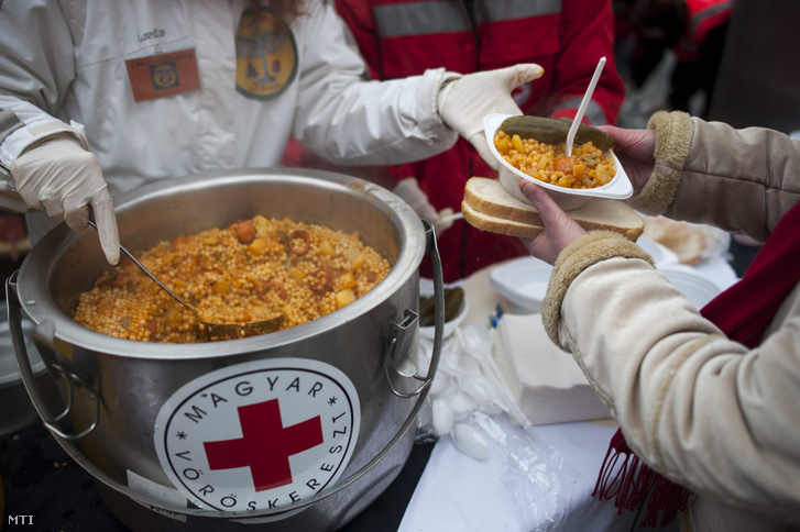 A Magyar Vöröskereszt Fővárosi Szervezetének tagjai ételt osztanak a fővárosi Nyugati téren 2013. december 13-án.
