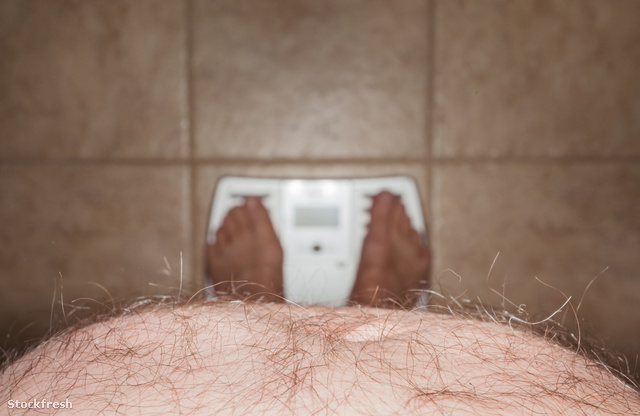 stockfresh 1673766 hairy-man-stomach-overhangs-feet-on-scales si