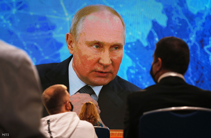 Vlagyimir Putyin orosz elnök (a kivetítőn) a koronavírus-járvány miatt videókonferencia keretében tart évértékelő sajtótájékoztatót Moszkvában 2020. december 17-én