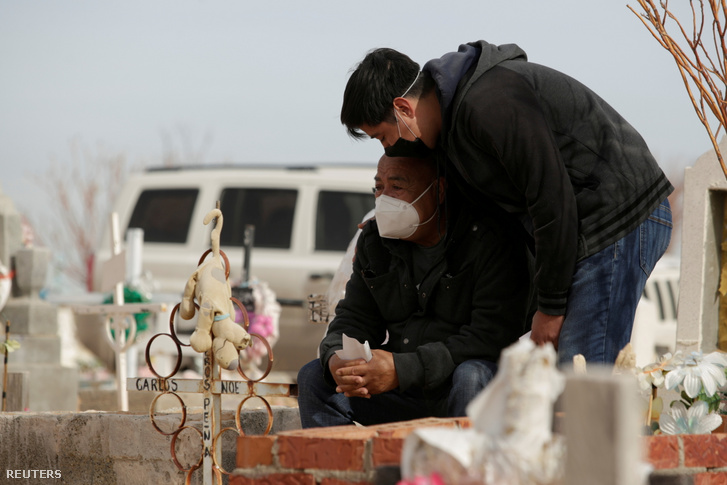 Koronavírus-fertőzésben meghalt felesége sírjánál sír Lorenzo Ramirez és fia, Jesus a mexikói Ciudad Juarez San Rafael temetőben 2020. december 24-én