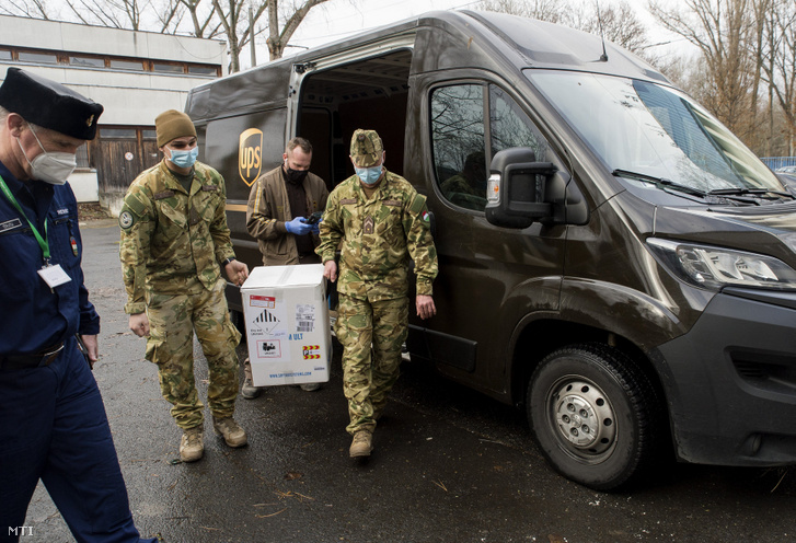 A győri Petz Aladár Megyei Oktató kórházba érkezett Pfizer-BioNTech vakcinákat tartalmazó dobozt katonák viszik 2020. december 30-án.
