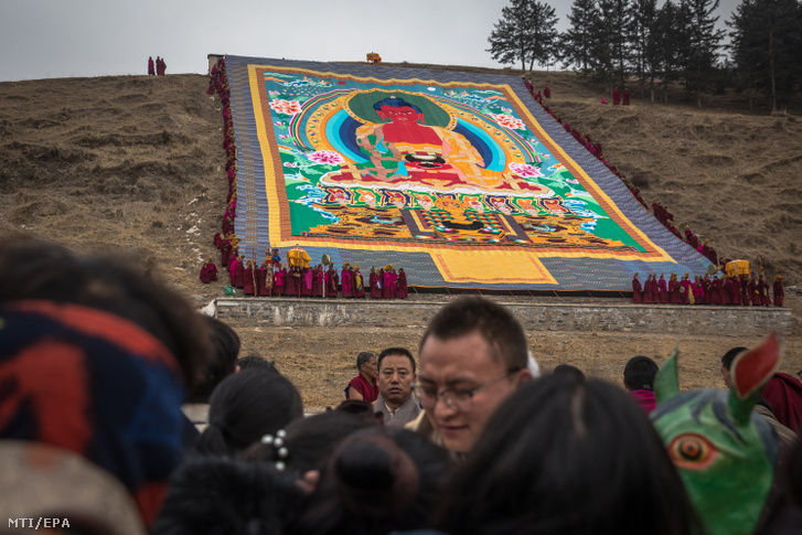 Tibeti buddhista szerzetesek szakrális textíliát, úgynevezett thangkát terítenek ki egy domboldalon a Monlam-imafesztiválon az északnyugat-kínai Kanszu tartománybeli Hsziahóban 2019. február 17-én. A hatalmas szövetre festett Buddha-ábrázolást a Labrang-kolostor közelében helyezik el a zarándokok ezreivel együtt tartandó közös fohászkodás előtt. A fesztivál a tibeti újév után három nappal veszi kezdetét, és közel két héten át tart.