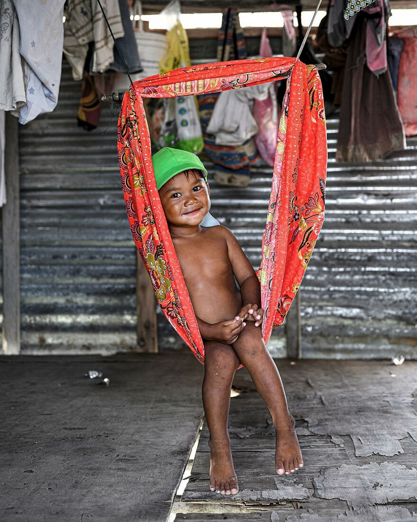 Malajziában a hinta egy kifeszített drótra rögzített, hatalmas kendőből áll. A kisfiú így is boldogan mosolyog.