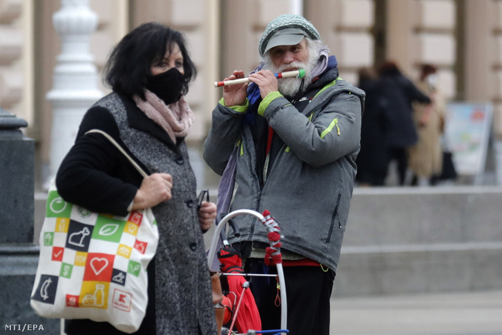 A koronavírus-járvány miatt védőmaszkot viselő járókelő egy zágrábi utcán