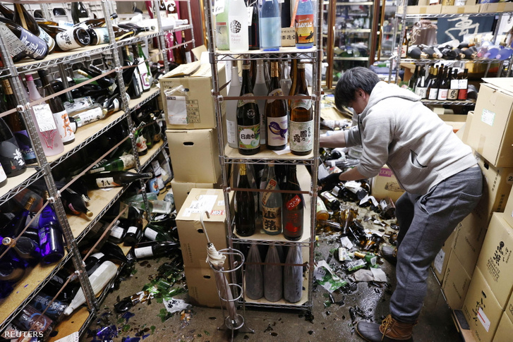 Eladó takarít egy italboltban a földrengés után Fukusimában 2021. február 13-án.