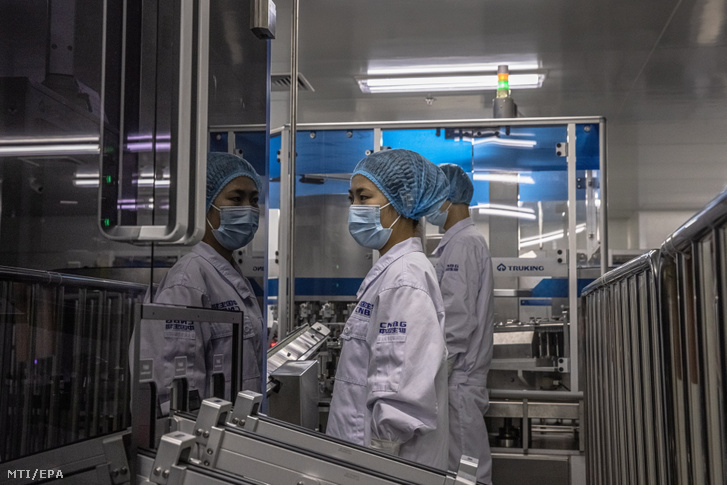 Alkalmazottak állnak a Sinopharm kínai állami gyógyszergyártó leányvállalataként működő China National Biotec Group (CNBG) pekingi vakcinacsomagoló üzemében 2021. február 26-án