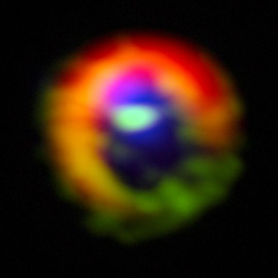 A HD 142527 körüli protoplanetáris korongnak az ALMA-észlelések alapján készült hamisszínes képe. A diszk külső részében a vörös szín a port jelzi, a zöld a sűrű gázt, illetve a résen átívelő gázáramokat, míg a résben megmaradt diffúz gázt a kék szín kódolja. A most detektált gázáramok 3 és 10 óra körüli pozícióknál figyelhetők meg. A sűrű gáz eloszlását a HCO+, míg a diffúz gázét a CO rajzolja ki. A külső diszk mérete körülbelül 2 fényév: ha az egész objektumot a Naprendszer helyébe képzeljük, akkor a legmesszebbre jutott ember által készített eszköz, a Voyager 1 most járna a belső pereménél
