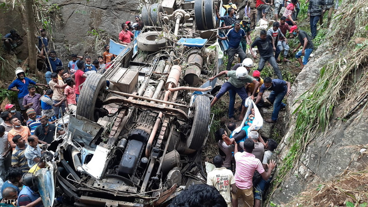 Mentőalakulatok tagjai és rendőrök az utasokat mentik Srí Lanka déli részén Passara település közelében ahol szakadékba zuhant egy busz 2021. március 20-án.
