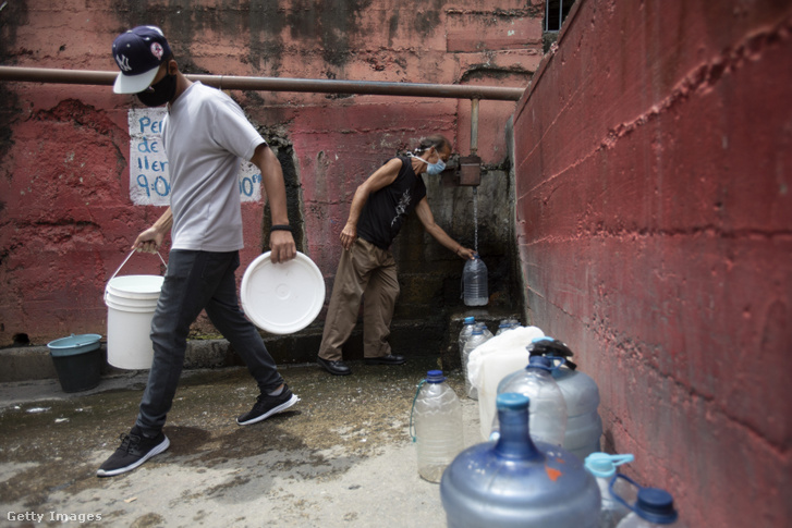 Férfi vízzel tölt fel egy palackot 2020. május 27-én Venezuela fővárosában, Caracasban