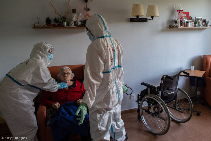 Ápólónők egy koronavírussal fertőzött idős betegnél tesznek ellenőrző látogatást Spanyolországban 2020. május 13-án