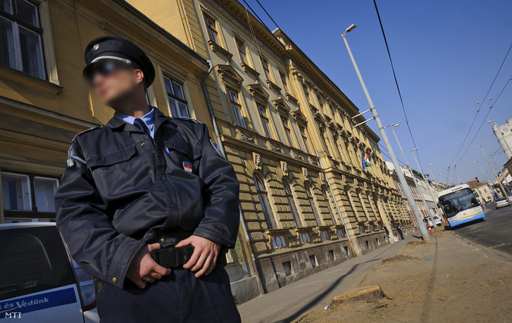 Egy rendőr áll a Debreceni Törvényszék előtt, miután az épületet bombariadó miatt kiürítették 2012. március 21-én