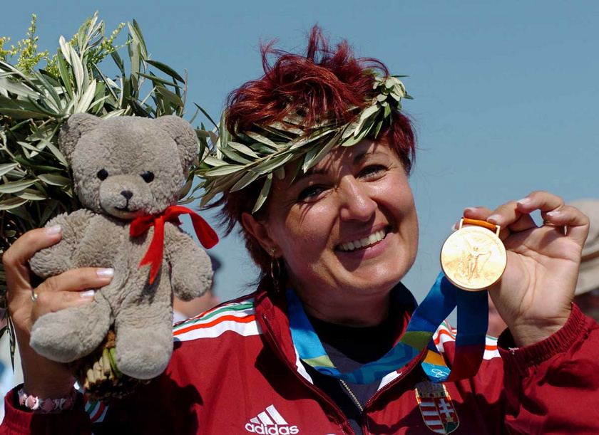 Az olimpiai bajnok Igaly Diána mosolyogva mutatja aranyérmét a női skeetlövők versenyének eredményhirdetésén 2004. augusztus 19-én a XXVIII. nyári olimpián.