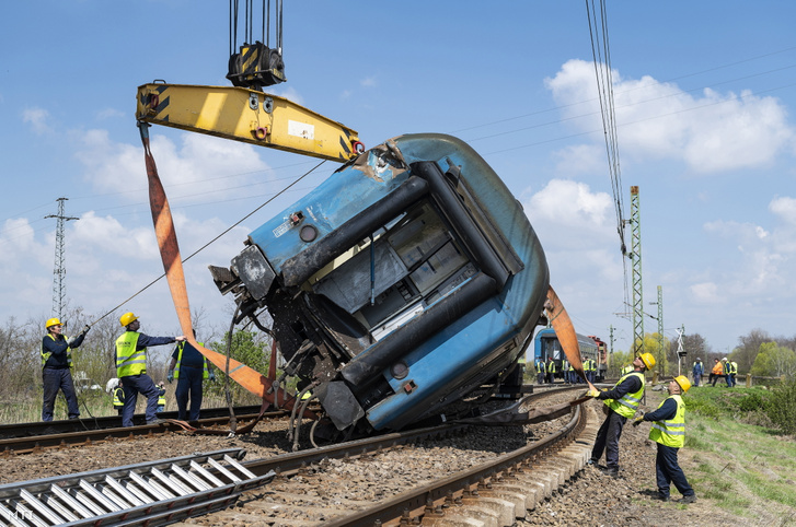 Az előző napon kisiklott vonat műszaki mentésén dolgoznak szakemberek Újfehértó határában 2021. április 21-én.