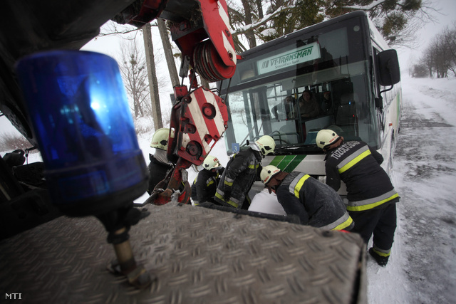 A hófúvásban elakadt munkásokat szállító buszt próbálják kimenteni a tűzoltók a Zala megyei Zalaszentbalázs határában