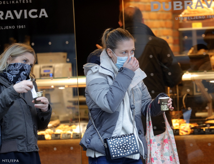 A koronavírus-járvány miatt védőmaszkot viselő járókelők elvitelre vásárolt kávéval egy zágrábi utcán 2021. január 29-én. Az előző 24 órában 619 új fertőzöttet azonosítottak Horvátországban MTI / EPA / Antonio Bat