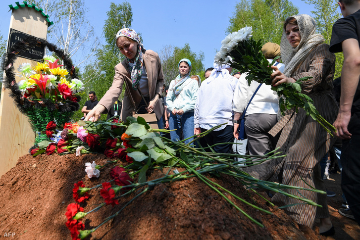 Gyászolók virágokat helyeznek az iskola angoltanárának, Elvira Ignatyevának a sírjára 2021. május 12-én
