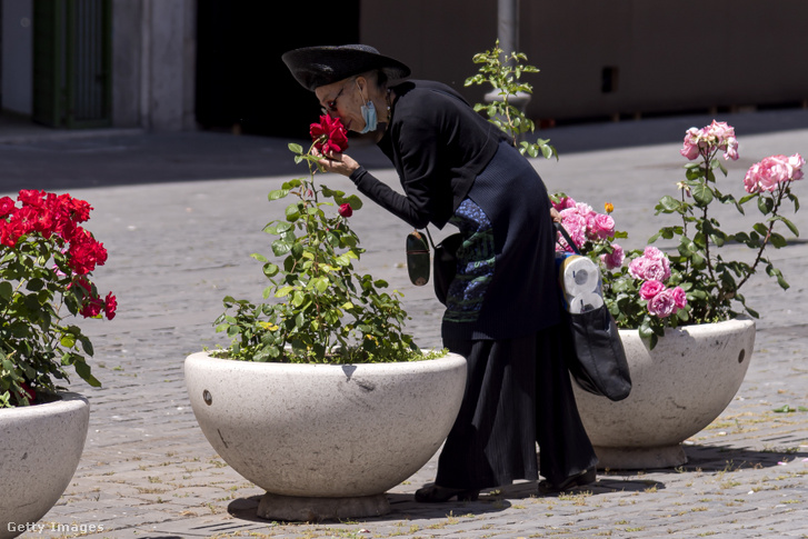 Egy nő virágokat szagol 2020. május 15-én Rómában, Olaszországban
