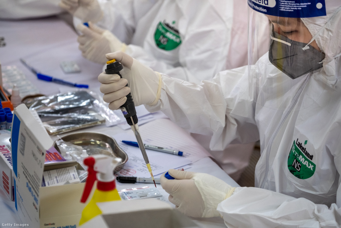 Védőruhás szakorvosok vérmintákon dolgoznak egy laboratóriumban Vietnámban 2020. április 18-án