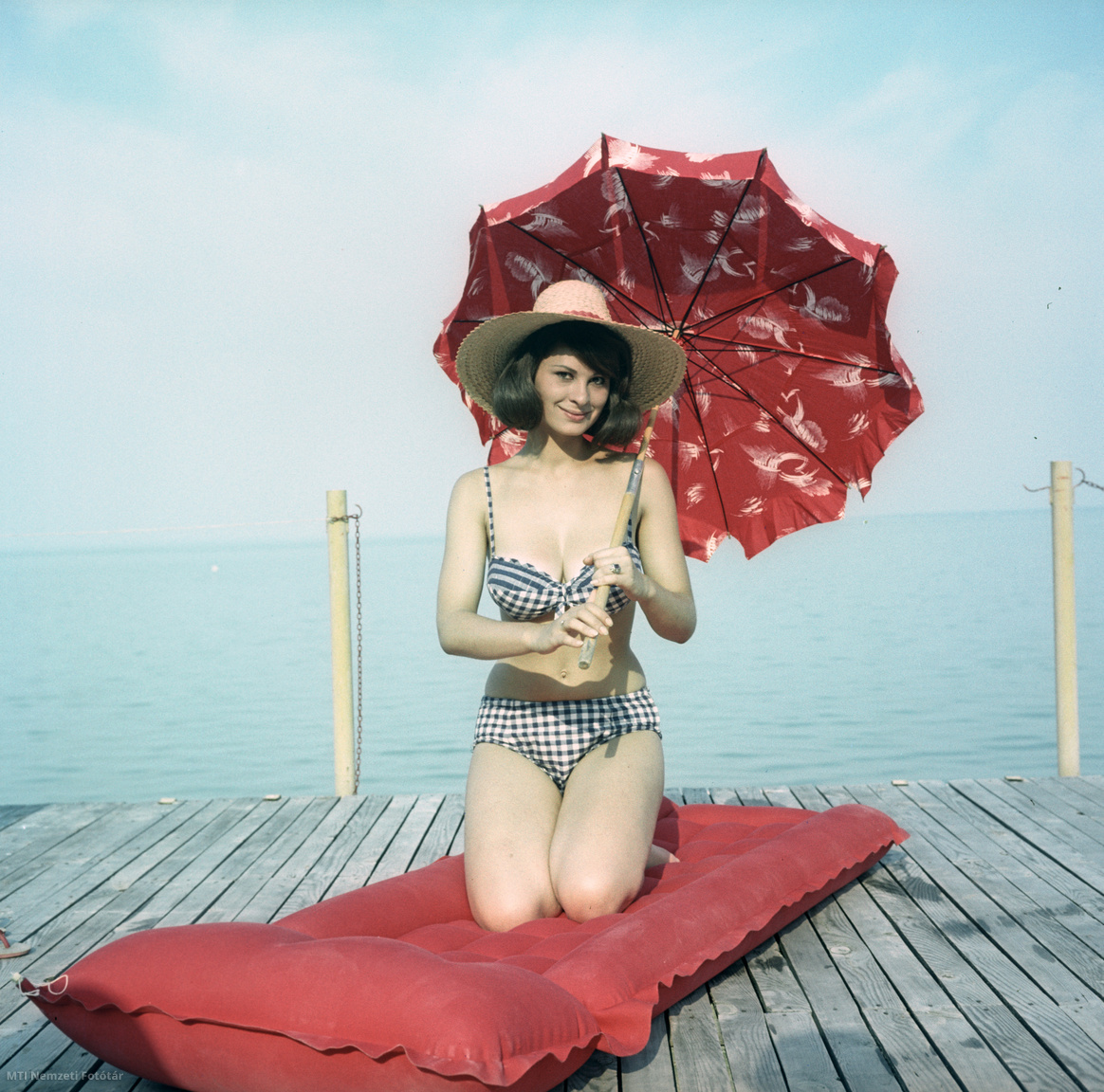 1963. július 21. Fiatal nő napernyővel pózol egy gumimatracon a Balaton partján a Tihany Szálloda és Motel előtt lévő strandon
