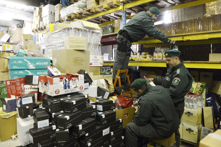 A Nemzeti Adó- és Vámhivatal munkatársai lejárt minőségmegőrzési idejű élelmiszerek átvizsgálását végzik egy törökbálinti raktárban 2014. március 18-án.