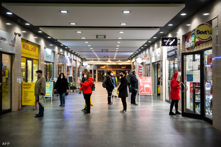 Az emberek távolságot tartanak sorban állás közben egy pozsonyi bevásárlóközpontban 2021. április 19-én