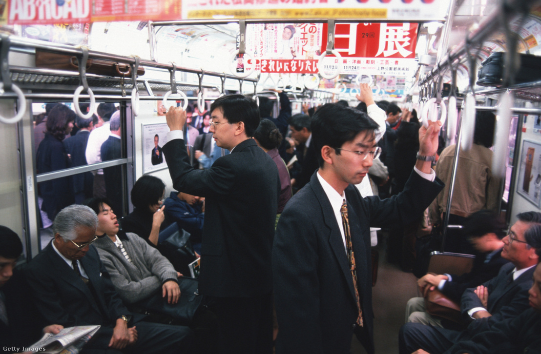 Japánok utaznak a metrón Tokióban