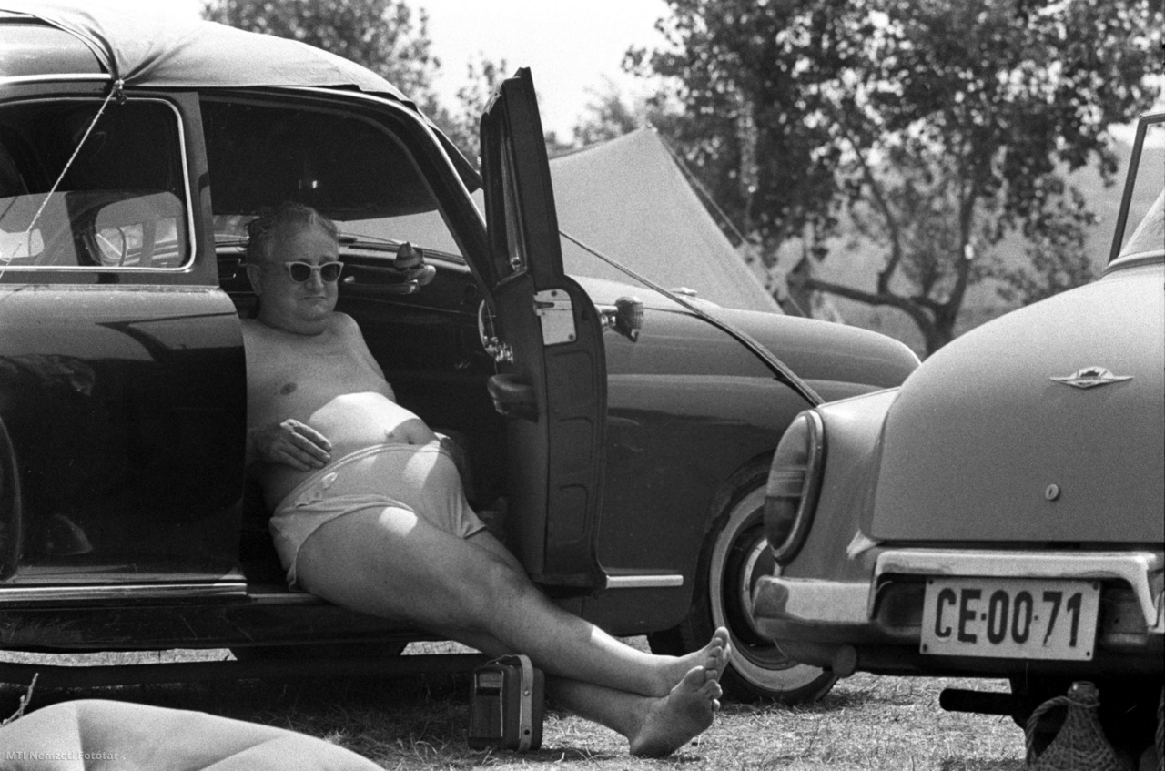 Balaton, 1963. augusztus 4. Kempingező férfi az autó árnyékában rádiózik a Balaton partján
