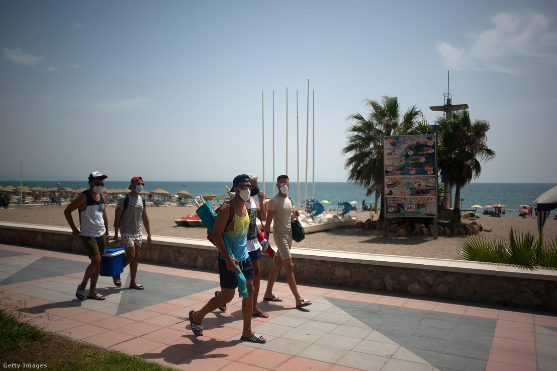 Arcmaszkot viselő emberek sétálnak Málaga város egyik strandján Spanyolországban 2020. augusztus 1-jén