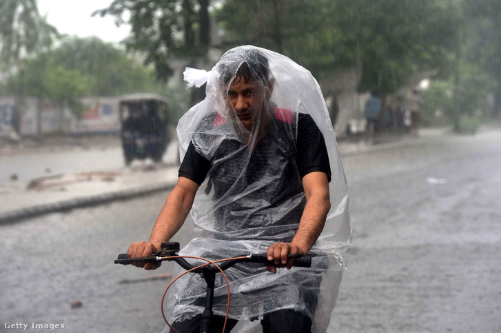 Egy férfi munkába biciklizik monszun idején az indiai Gurugramban 2021 július 27-én