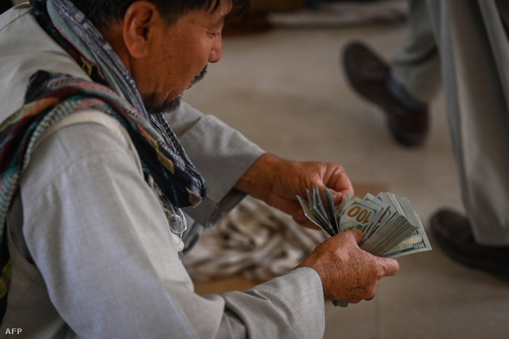 Egy afgán kereskedő készpénzt számol egy piaci területen Kabulban 2021. szeptember 5-én