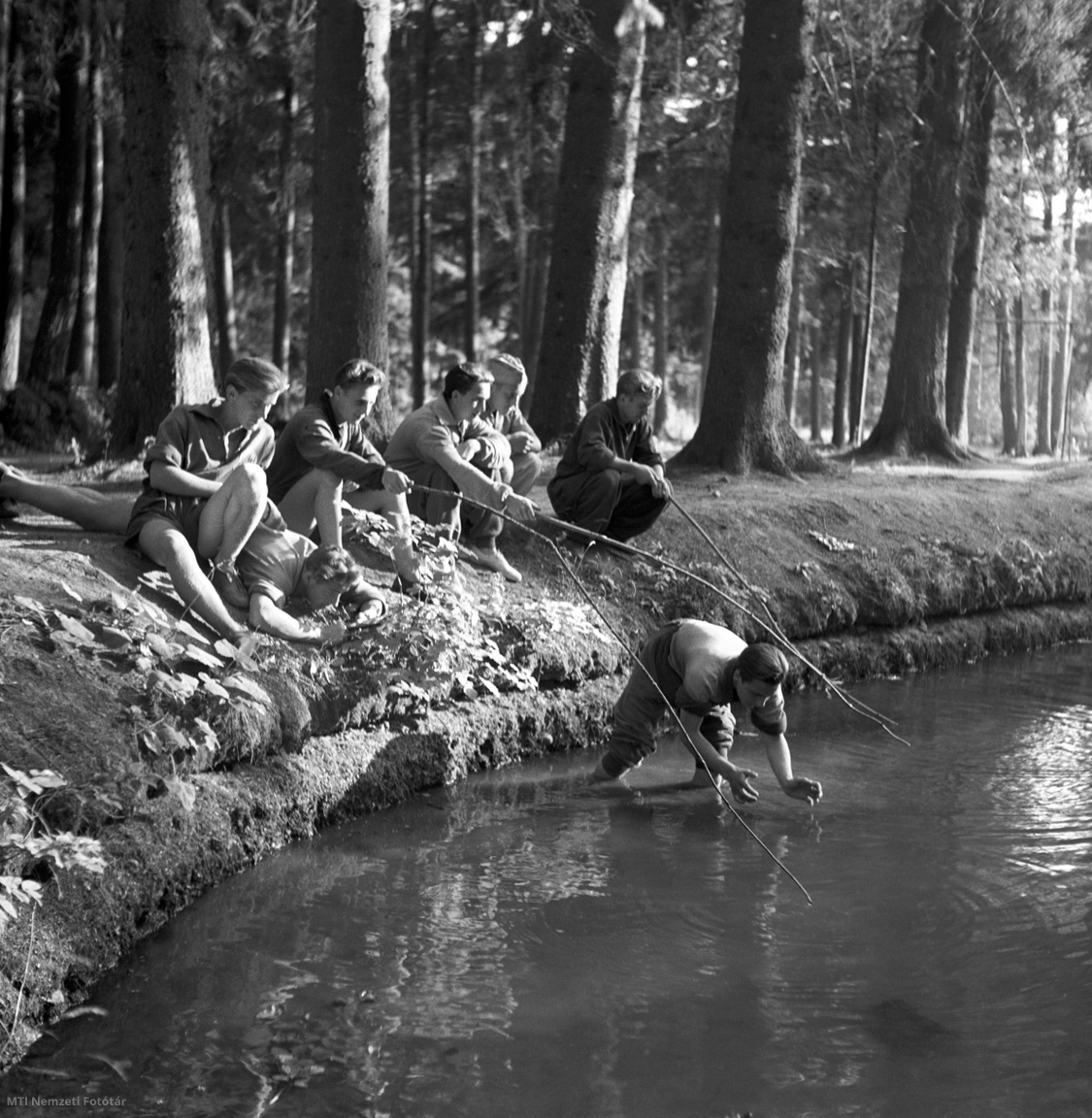 Bükkszentkereszt, 1955. július 14. Az újhutai tó partján üldögélő, horgászó fiúk az 1950-ben alakult MTH (Munkaerő-tartalékok Hivatala) ipari tanuló üdültetésén Újhután (1940-től Bükkszentkereszt). A képriport a Munkaerőtartalék Hivatal megrendelésére készült