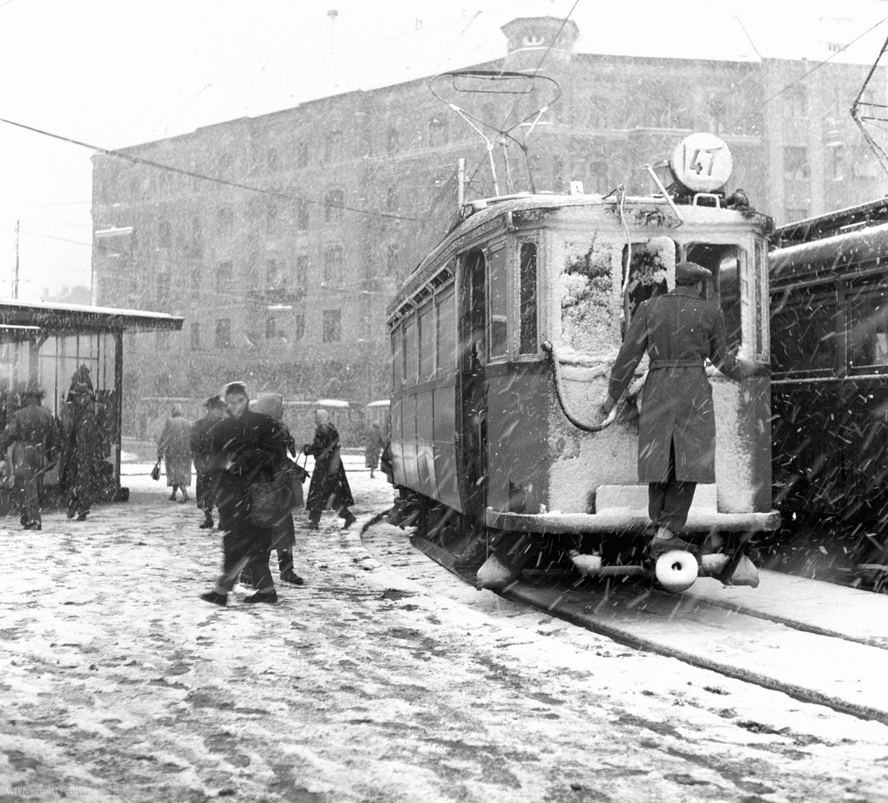 A 47-es villamos vezetője letakarítja a rárakódott havat a villamos szélvédőjéről a budafoki vonal végállomásán, a Móricz Zsigmond körtéren. Ezen a napon – 1959. január 9-én – az erős havazás megnehezítette a budapesti közlekedést