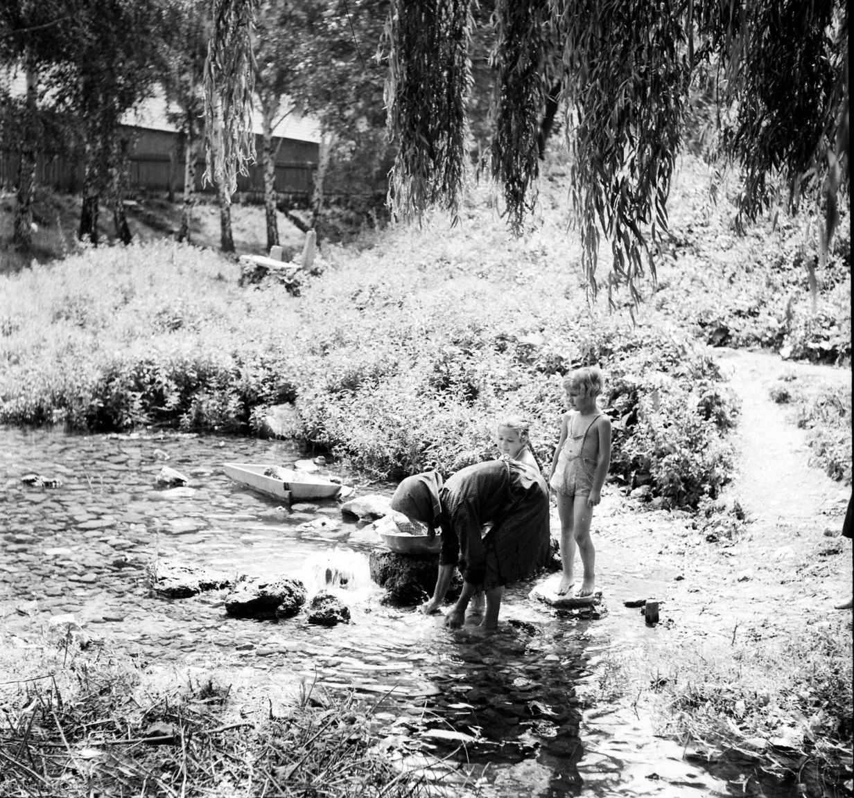Miskolc, 1951. július 9. Egy asszony ruhát mos a Szinva-patakban, két kislány nézi őt. A felvétel az Miskolcot bemutató IBUSZ-képsorozat része.