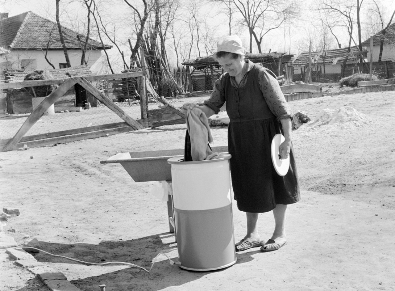 Tiszacsege, 1969. április 12. Egy asszony mos géppel falusi háza udvarán. Tiszacsege az Árpád-kortól létező település. A mezőgazdaság mellett a turizmussal foglalkoznak lakói. Városi rangot kapott 2000. július 1-én.