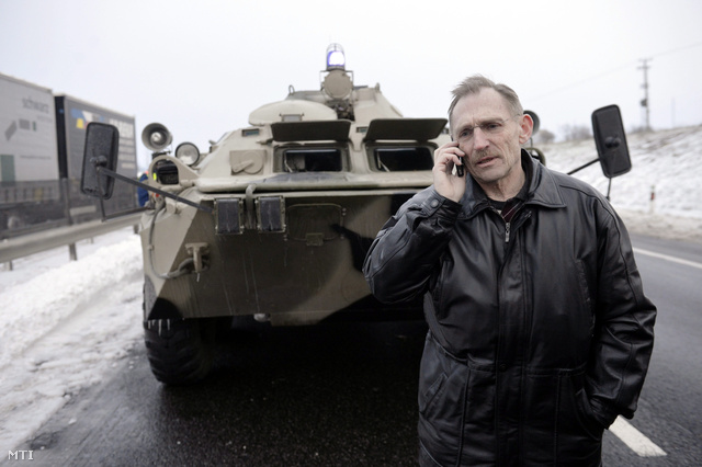 Pintér Sándor belügyminiszter egy páncélozott jármű előtt telefonál az M1-es autópályán Bábolna mellett.