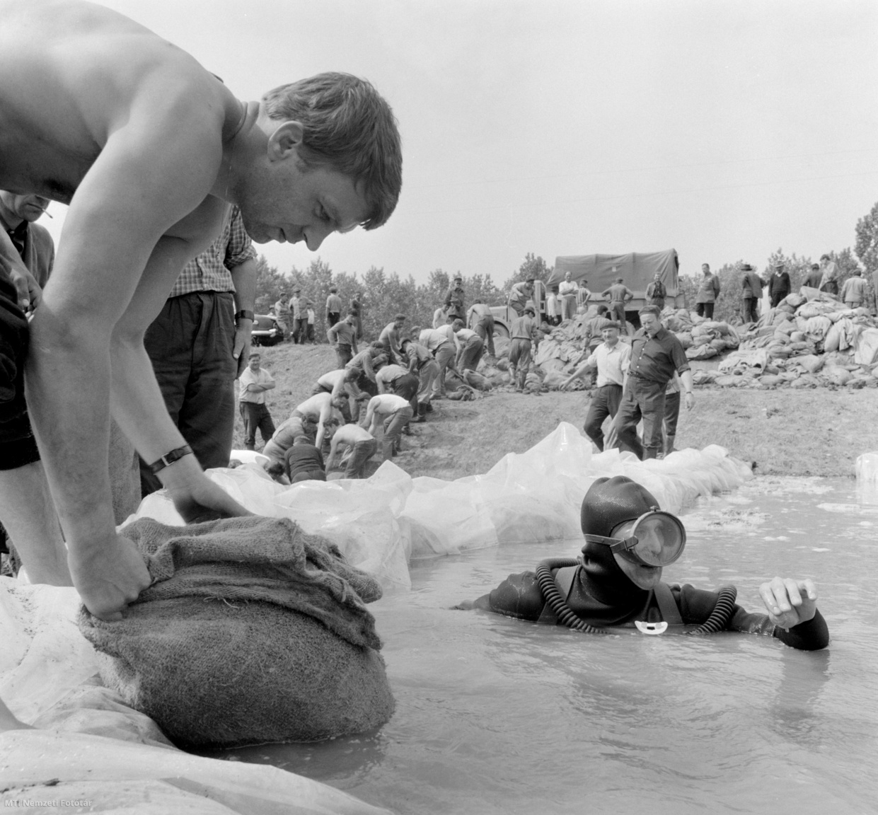 Makó, 1970. május 21. Homokzsákot visz könnyűbúvár a mélybe egy buzgár szivárgásának megszüntetésére Makónál, ahol a Maros árhulláma ellen védekeznek