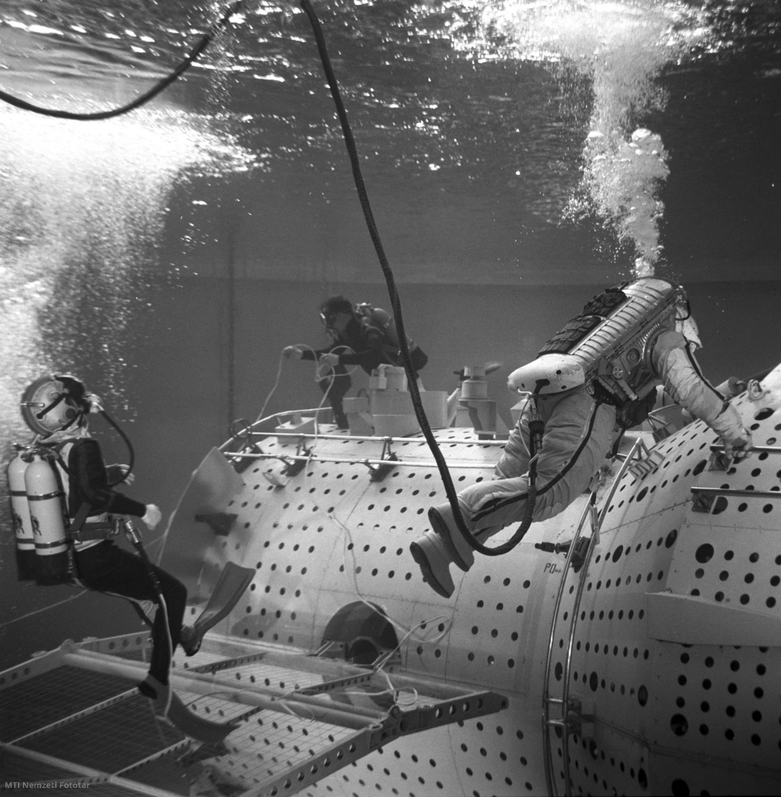 1980. április 12. Farkas Bertalan magyar és Valerij Kubaszov szovjet űrhajós szkafanderben gyakorol a Szaljut űrállomás víz alatti makettjében, munkájukat könnyűbúvárok vigyázzák. Farkas Bertalan és Valerij Kubaszov 1980. május 26-án indult a világűrbe a Szojuz–36 űrhajó fedélzetén. A Szaljut–6 űrállomáson Leonyid Popov és Valerij Rjumin szovjet űrhajósok fogadták őket. A nyolcnapos úton Farkas a magyar kutatóintézetek által tervezett orvosbiológiai, fémtechnológiai, fizikai, távérzékelési és erőforrás-kutatási kísérleteket és megfigyeléseket hajtotta végre. 1980. június 3-án tértek vissza a Földre a Szojuz–35 űrhajó fedélzetén