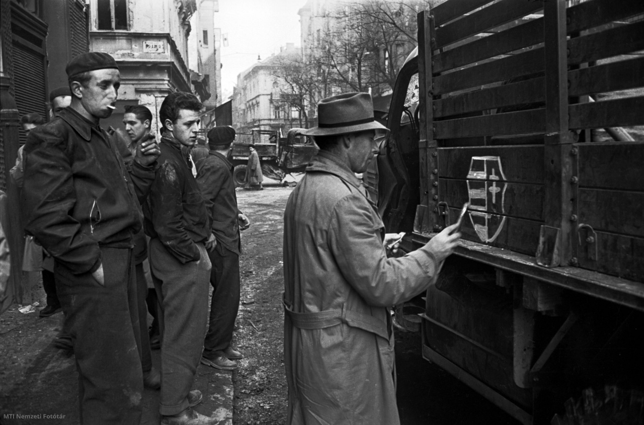 Budapest, 1956. október. Kossuth-címert fest egy férfi egy teherautó oldalára a sarlót és kalapácsot ábrázoló kommunista szimbólum helyébe. A felvétel készítésének pontos időpontja ismeretlen