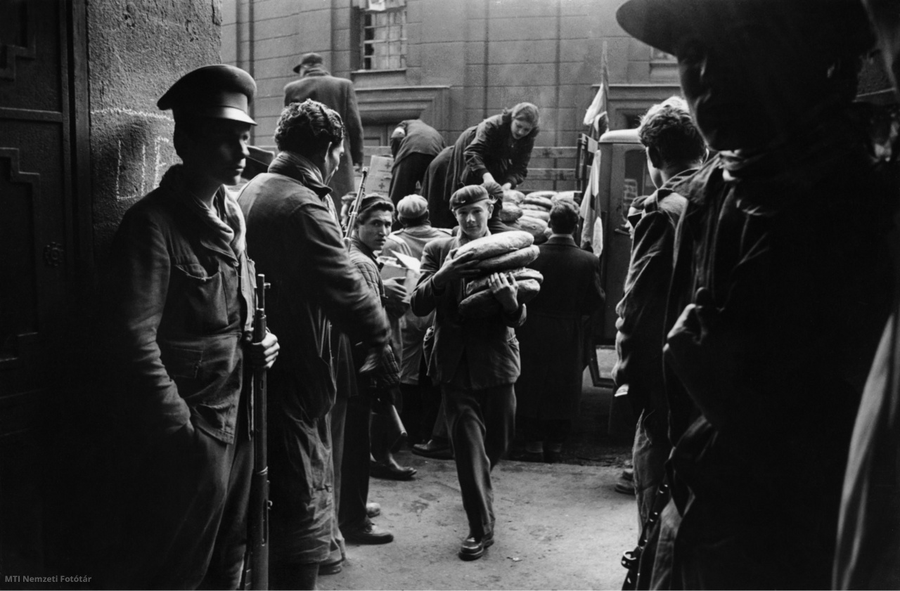 Budapest, 1956. október. Teherautóról lepakolt kenyereket visznek be fiatalok a Pongrátz Gergely vezette Corvin közi felkelőcsoport központjába, amelynek bejáratánál fegyveres férfiak állnak őrt. A felvétel készítésének pontos időpontja ismeretlen
